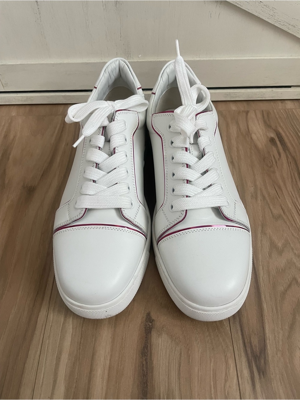 Women’s white with pink Christian Louboutin sneakers.